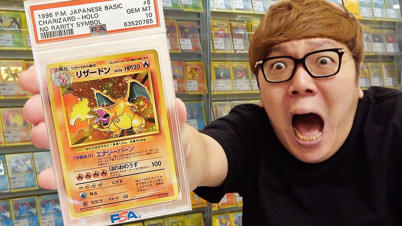 PSA10のかいりきリザードンを手にするHIKAKINさん。鑑定ラベルには「GEM MT 10」「NO RARITY SYMBOL」とある